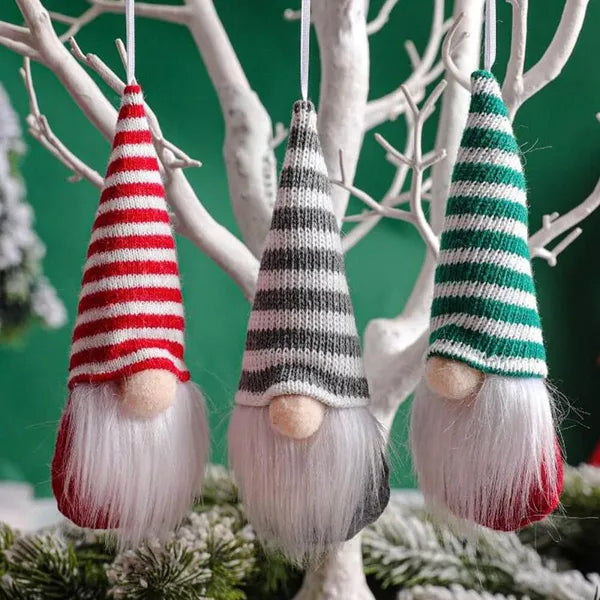 Three striped gnome ornaments hanging from branches with a green background