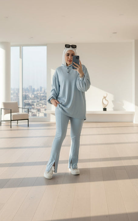 Person taking a mirror selfie wearing a light blue outfit with 'Emo' branding.