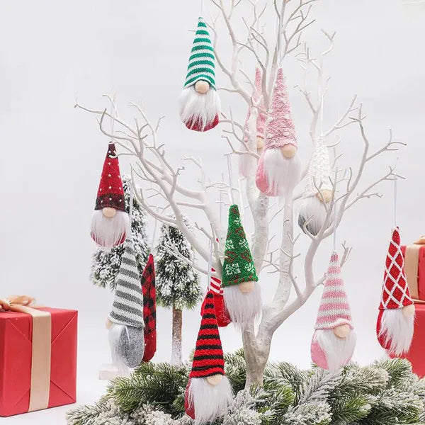 Decorative Christmas gnomes hanging from a branch with a white background